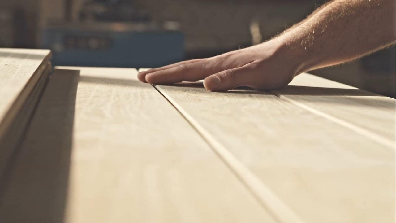 Zimmerer bei der Arbeit an einem Holzbalken